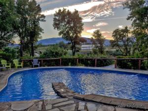 a swimming pool in a yard with chairs and trees at La Simona Casa Rural in Perales del Puerto