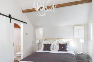 a bedroom with a bed and a chandelier at The Cottage and The Nook in Gretton