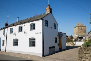 a white building on the side of a street at The Cottage and The Nook in Gretton
