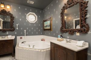 a bathroom with a tub and a sink and mirrors at Montgomery Inn BnB in Versailles