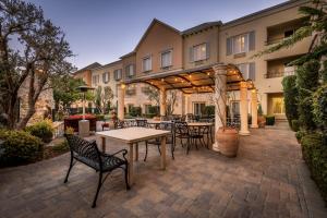 a patio with tables and chairs in front of a building at Ayres Hotel Seal Beach in Seal Beach