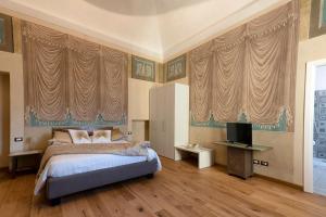 una camera con letto, tende e TV di AGRITURISMO CASCINA GRAZIOSA a Cameriano