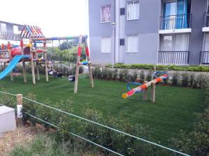 a group of playground equipment on a lawn in front of a building at APARTAMENTO AVENIDA CONDINA Primer Piso in Pereira