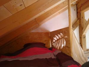 Posto letto in una camera mansardata in legno con: di Elément-Terre ad Aigle