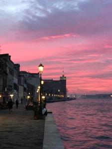 una luz de la calle junto al agua al atardecer en Nice & Cozy apartment, en Venecia