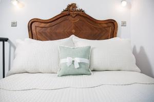 a bed with white pillows with a bow on it at The Nook, Gretton (Cotswolds) in Gretton