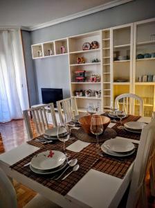 a dining room table with plates and wine glasses at A pocos minutos del centro con PARKING GRATIS en el edificio Nº REGISTRO Vu-74 in Salamanca