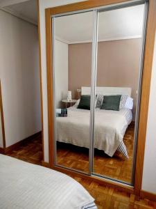 ein Spiegelreflex aus einem Schlafzimmer mit einem Bett in der Unterkunft A pocos minutos del centro con PARKING GRATIS en el edificio Nº REGISTRO Vu-74 in Salamanca