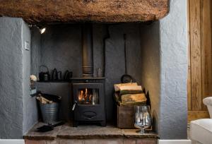 a fireplace in a room with a stove at The Nook, Gretton (Cotswolds) in Gretton