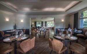 - un restaurant avec des tables et des chaises dans une salle dans l'établissement Hotel Mardaga, à As