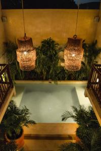 a room with two chandeliers and potted plants at ALCOBAS DEL MAR in Holbox Island