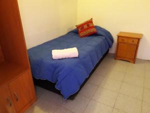 a bed in a bedroom with a blue blanket at Hostal Las Kañas in San Pedro de Atacama