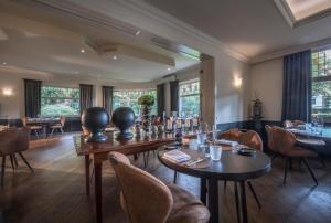 ein Esszimmer mit Tischen und Stühlen und Fenstern in der Unterkunft Hotel Mardaga in As + 37 Fotos