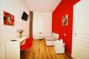 Habitación roja con escritorio y cama en Torino 1854 Affittacamere en Turín