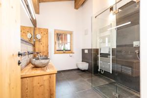 łazienka z umywalką i przeszkloną kabiną prysznicową w obiekcie Chalet Waschkuchl w Alpbach