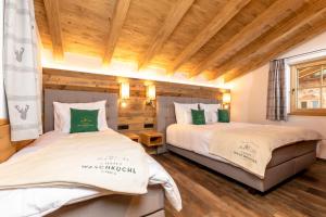 dwa łóżka w pokoju z drewnianym sufitem w obiekcie Chalet Waschkuchl w Alpbach