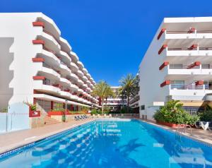una imagen de una piscina frente a un edificio en Apartamentos Lido, en Ibiza