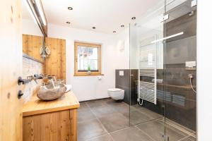 łazienka z umywalką i przeszkloną kabiną prysznicową w obiekcie Chalet Waschkuchl w Alpbach