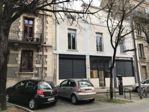 due auto parcheggiate in un parcheggio di fronte a un edificio di STUDIO LE CHOUETTE a Digione