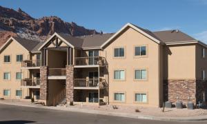 an apartment building with a mountain in the background at Moab Redcliff Condos in Moab