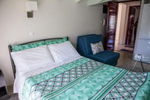 ナフプリオにあるBlue Skyのベッドルーム1室(ベッド1台、青い椅子付)