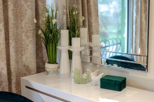 ein weißer Tisch mit Vasen und Kerzen darauf in der Unterkunft Reichel-Appartements in Baden-Baden