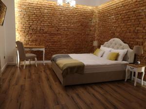 a bedroom with a bed and a brick wall at ApatramentyMer Ryn - Idealny dla Ciebie in Ryn