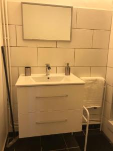 een badkamer met een witte wastafel en een spiegel bij The Cocooning in Tours