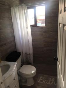 um banheiro com vaso sanitário, pia e janela em Los Pinos de Quilvo em Romeral