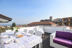 un tavolo e sedie su un balcone con vista di My Desenzano Exclusive Home a Desenzano del Garda