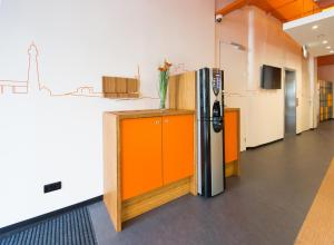 a kitchen with an orange and silver refrigerator at easyHotel The Hague City Centre in The Hague +27 photos