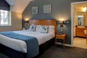 a bedroom with a large bed and a bathroom at Wild Pheasant Hotel & Spa in Llangollen
