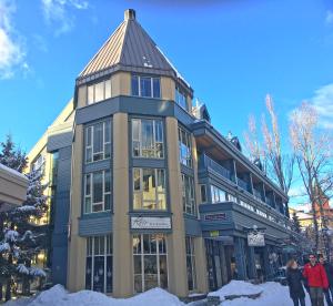 a building with people standing outside in the snow at Village Gate House by Whiski Jack in Whistler