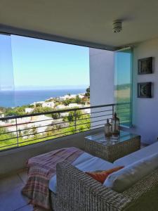 a bedroom with a balcony with a view of the ocean at Parador del Mar Marbella Maitencillo in Maitencillo
