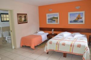 a hotel room with two beds and orange walls at Pousada Villa Harmonia in Paraty +87 photos