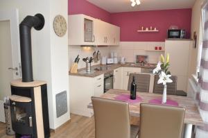 a kitchen with a table and a wood stove at Ferienhaus Müritzzauber / EG-Appartement in Marienfelde