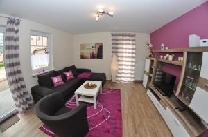 a living room with a couch and a tv at Ferienhaus Müritzzauber / EG-Appartement in Marienfelde