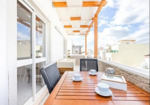 een houten tafel en stoelen op een balkon bij My Place @ Faro Ria Views in Faro