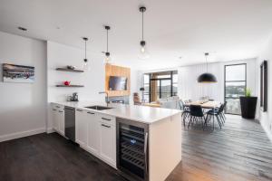 uma cozinha em plano aberto e sala de jantar com paredes brancas em Horizon 104 by Tremblant Prestige em Mont-Tremblant