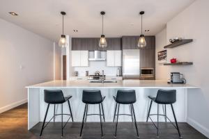 a kitchen with a large island with blue bar stools at Tremblant Prestige - Horizon 1-104 in Mont-Tremblant +16 photos