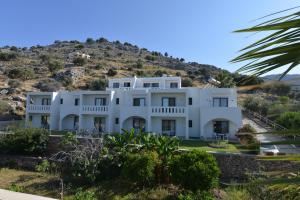 a white house with a hill in the background at Golden View Studios in Lindos