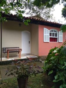 une maison avec un banc devant elle dans l'établissement Chalé da Paz, à Penedo