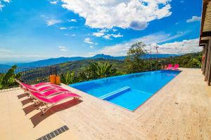 - une piscine avec des chaises et une vue sur les montagnes dans l'établissement Hotel Casa Portones, à San Bernardo