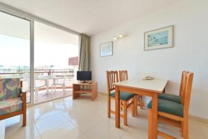 a living room with a table and chairs and a balcony at Apartamentos Lido in Ibiza Town