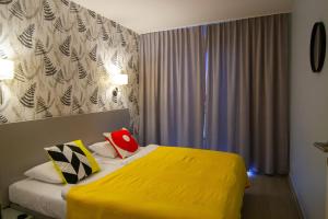 Habitación de hotel con cama con manta amarilla en Apartament 21 Czarna Góra, en Sienna
