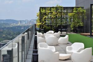 a row of white chairs on the roof of a building at Anggun Residences Luxe in Kuala Lumpur
