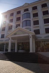 a large white building with a staircase in front of it at Windsor Hotel Son La in Sơn La