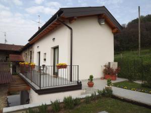 a white house with a black roof and a balcony at Agriturismo Cascina Rossano in Provaglio d'Iseo