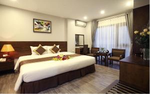 a hotel room with a large bed with flowers on it at Blue Pearl West Hotel in Hanoi
