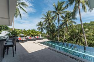 an infinity pool at a resort with palm trees at Villa Zendo in Mae Nam